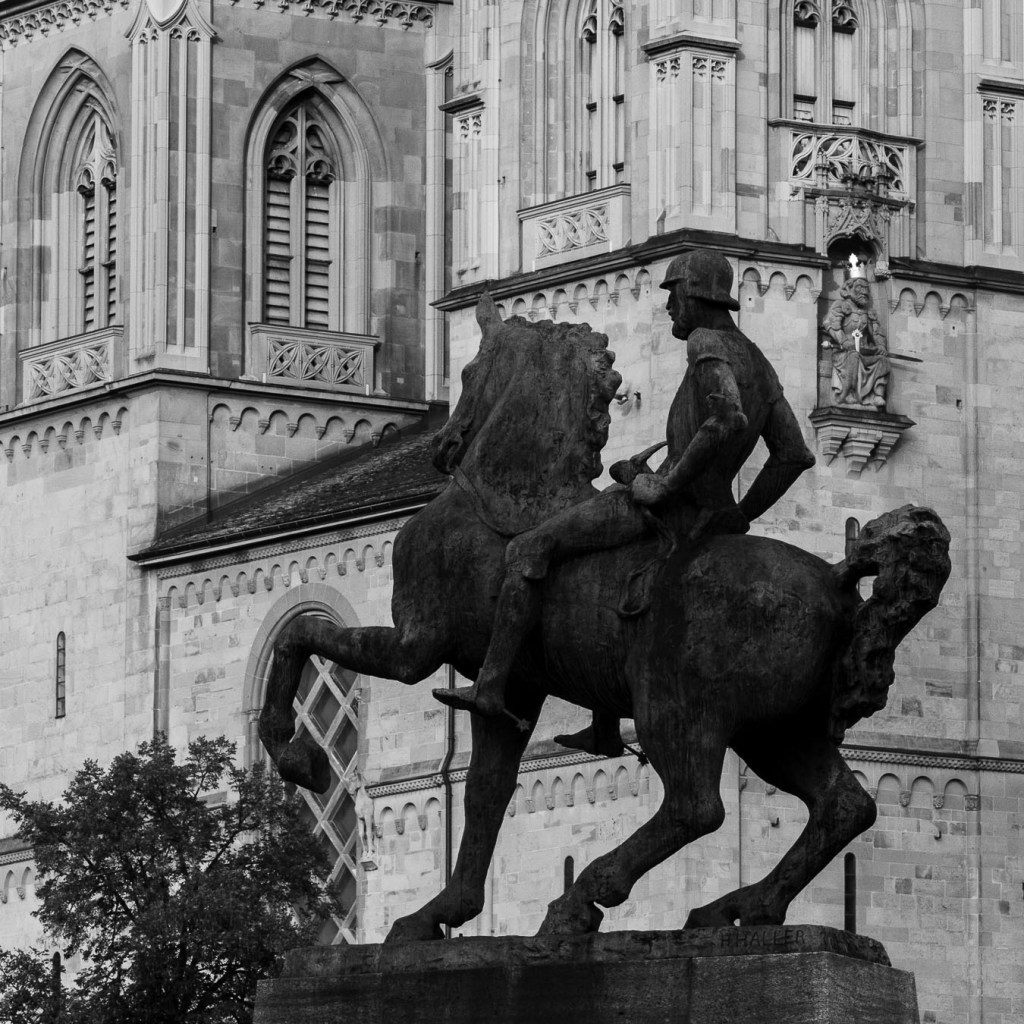 Bronze equestrian statue in front of Grossmünster church, Zurich historic monument in black and white