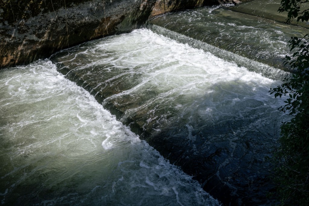 Close-up of turbulent water flowing over a concrete weir threshold, Bülach, Switzerland