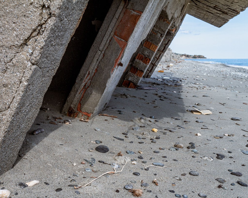 Sloping ruin sinking into the sandy beach, San Pasquale, Calabria